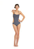 Full length portrait of happy young woman in swimsuit pointing i