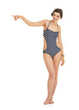 Full length portrait of happy young woman in swimsuit pointing o