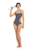 Full length portrait of happy young woman in swimsuit with bottl