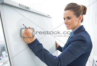 Closeup on business woman writing on flipchart