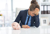 Frustrated business woman with piggy bank