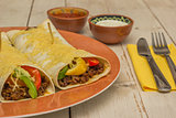 Burritos filled with ground beef and peppers, topped with cheese