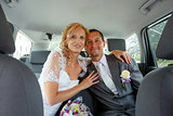 beautiful young wedding couple in car