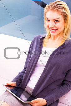 Smiling young woman holding digital tablet