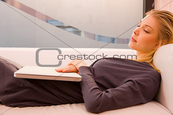 Young woman with laptop sleeping couch
