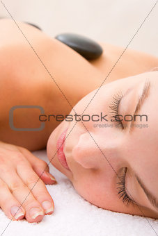 Young woman getting hot stone therapy