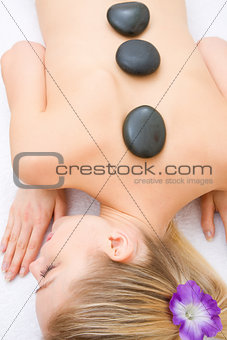Young woman receiving hot stone treatment