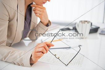 Closeup on eyeglasses in hand of business woman
