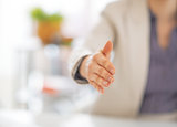 Closeup on business woman stretching hand for handshake