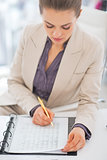 Portrait of business woman writing in document