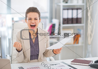 Happy business woman with document rejoicing