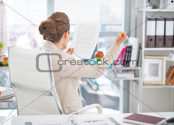 Happy business woman with document rejoicing at work. rear view