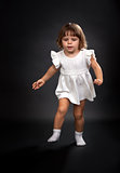 the first steps of a little girl on a black background.