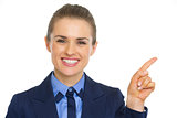 Portrait of smiling business woman pointing on copy space
