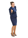 Full length portrait of happy business woman pointing in camera