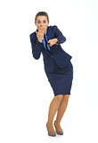 Full length portrait of surprised business woman pointing in cam
