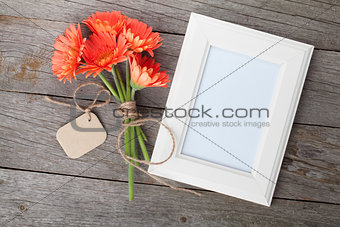 Bunch of gerbera flowers and photo frame