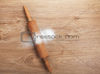 Rolling pin with flour on wooden table