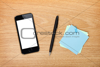 Office table with mobile phone and supplies
