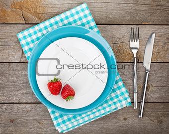 Plate with ripe strawberry and silverware