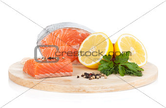 Salmon on cutting board with lemons and herbs