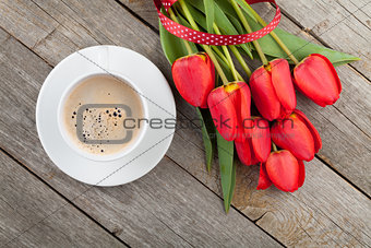 Fresh red tulips with ribbon and coffee cup