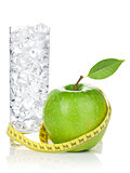 Fresh green apple with yellow measuring tape and glass of water