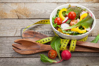 Fresh healthy salad, utensil and measure tape