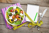 Fresh healthy salad and notepad for copy space