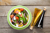 Fresh healthy greek salad and condiment bottles