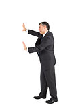 Mature businessman pushing with hands
