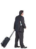 Mature businessman pulling his suitcase