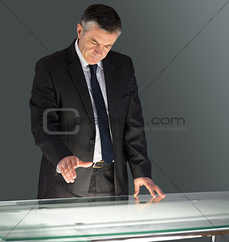 Concentrating businessman leaning on desk