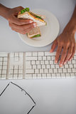 Businesswoman eating a sandwich at her desk