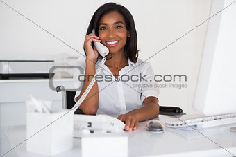 Smiling businesswoman in wheelchair working at her desk