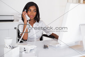 Happy businesswoman in wheelchair working at her desk