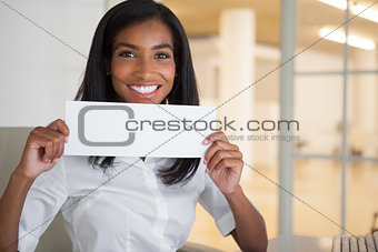 Pretty businesswoman showing white card at her desk