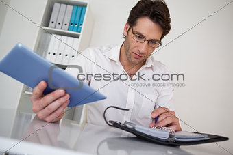 Casual businessman organizing his schedule at his desk