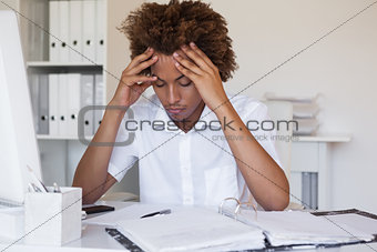 Casual stressed businessman with his head down at desk