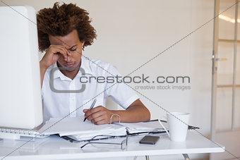 Casual stressed businessman working at his desk