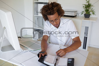 Casual young businessman organizing his schedule at his desk