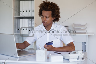Relaxed casual businessman shopping online at his desk
