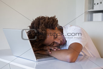 Casual businessman sleeping at his desk on his laptop