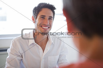 Casual business people talking at desk and smiling
