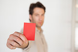 Casual businessman showing red card