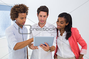 Three colleagues working on tablet pc