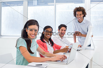 Workers using technology and smiling to the camera