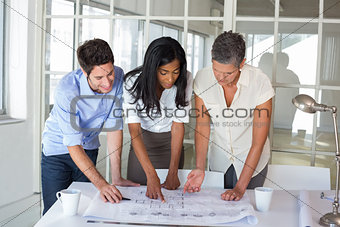 Three architects looking at blueprints