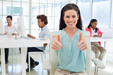 Attractive worker gives two thumbs up to camera