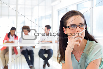 Attractive businesswoman contemplating while colleagues are in background
